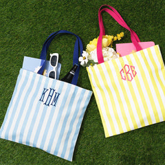 blue and yellow striped totes on grass monogram