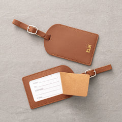 Two brown leather luggage tags with a gray background