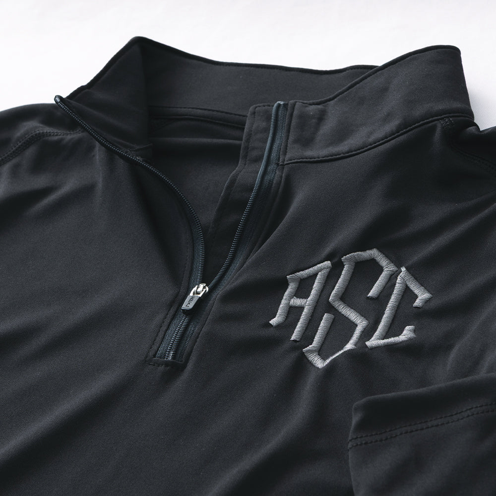 close up of black and grey monogrammed quarter zip pullover 