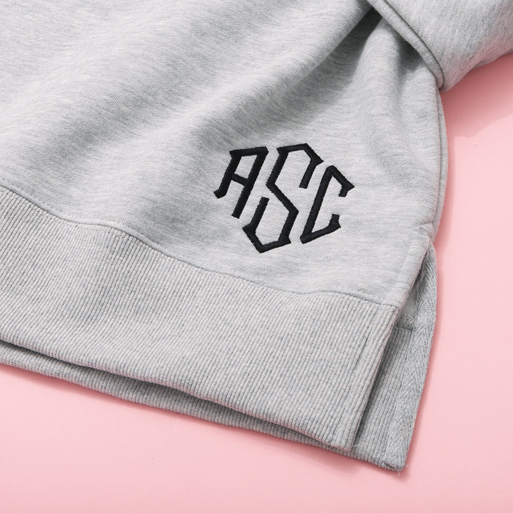close up of monogram on mockneck sweatshirt in heathered grey 