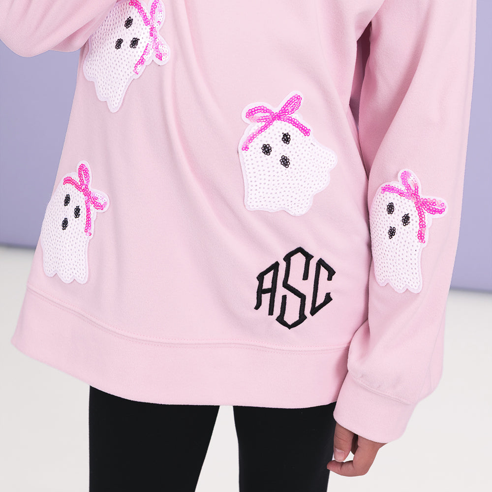 close up of monogram on sequin ghost sweatshirt in light pink 