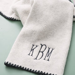 close up of monogrammed embroidered edge scarf in ivory and black