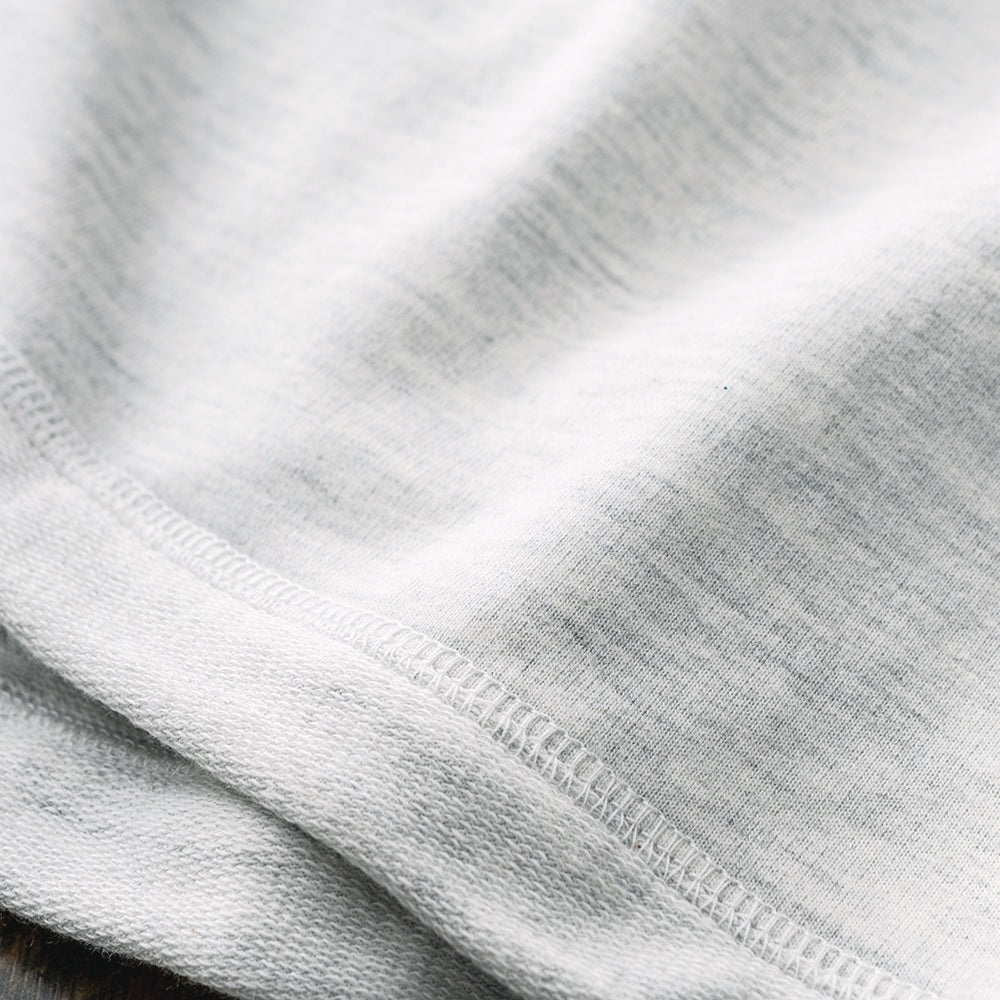 close up of monogrammed essential pullover in heathered ivory fabric 