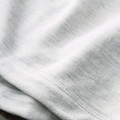 close up of monogrammed essential pullover in heathered ivory fabric 