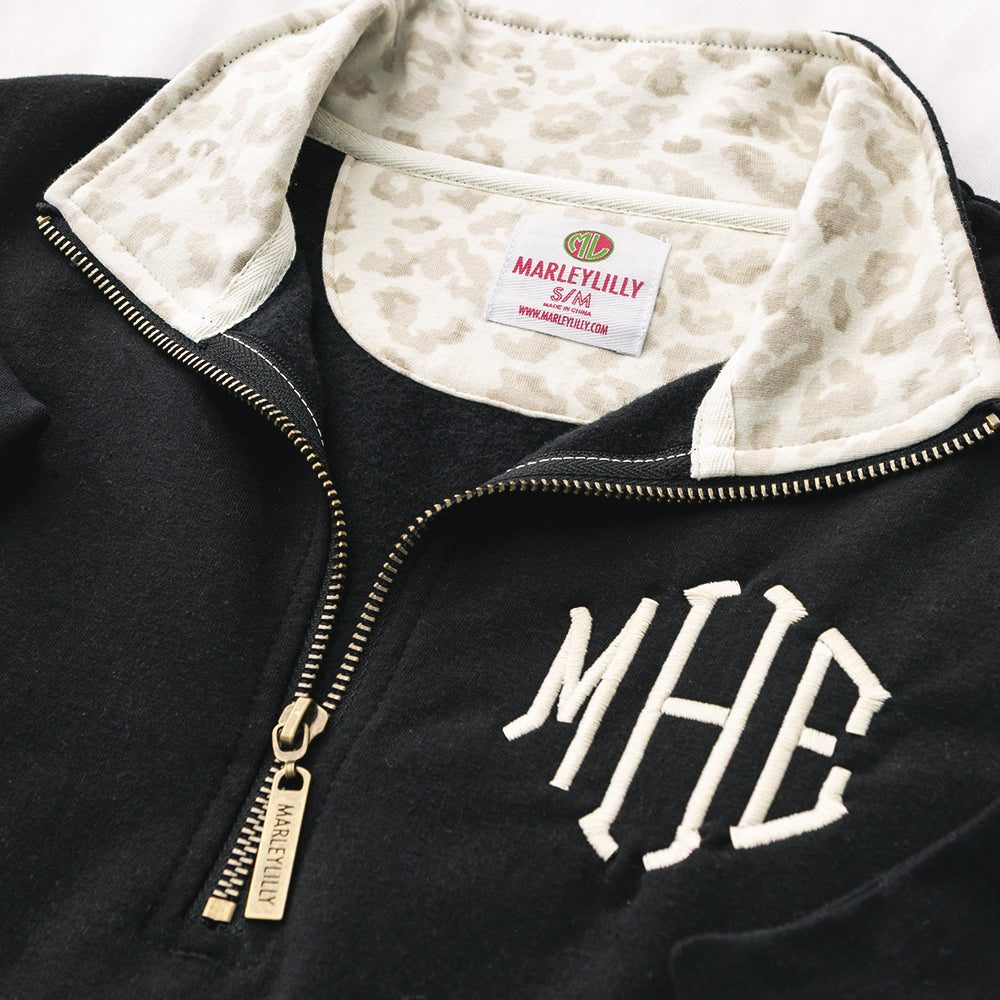 close up of monogrammed quarter zip sweatshirt in luxe leopard 
