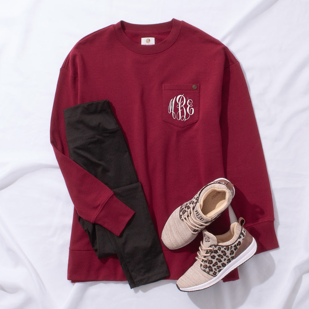 crimson crewneck outfit styled with leggings and leopard sneakers with white monogram