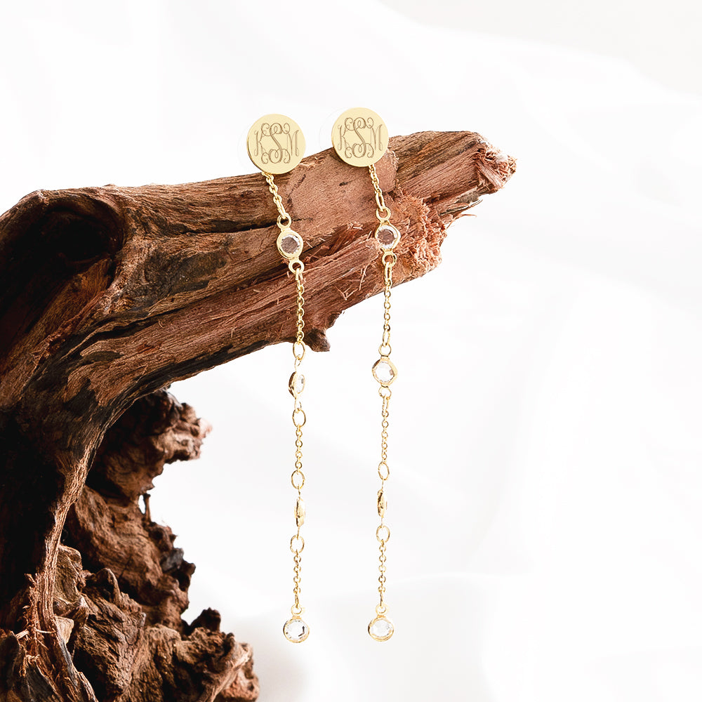 crystal duster earrings hanging on driftwood