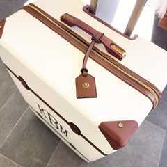 dark brown monogrammed bag tag on luggage