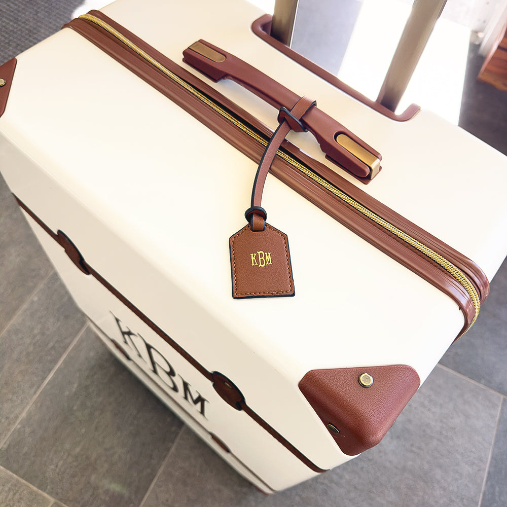 dark brown monogrammed bag tag on luggage