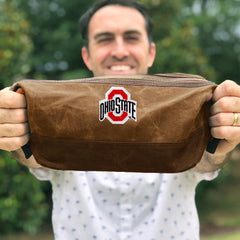 man holding ohio state waxed canvas dopp kit