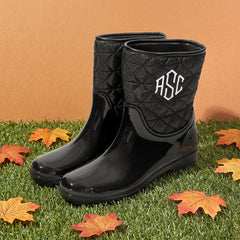 black rain boots with leaves on turf