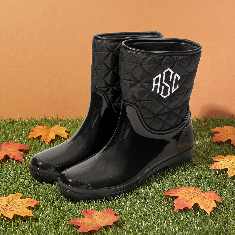 black rain boots with leaves on turf