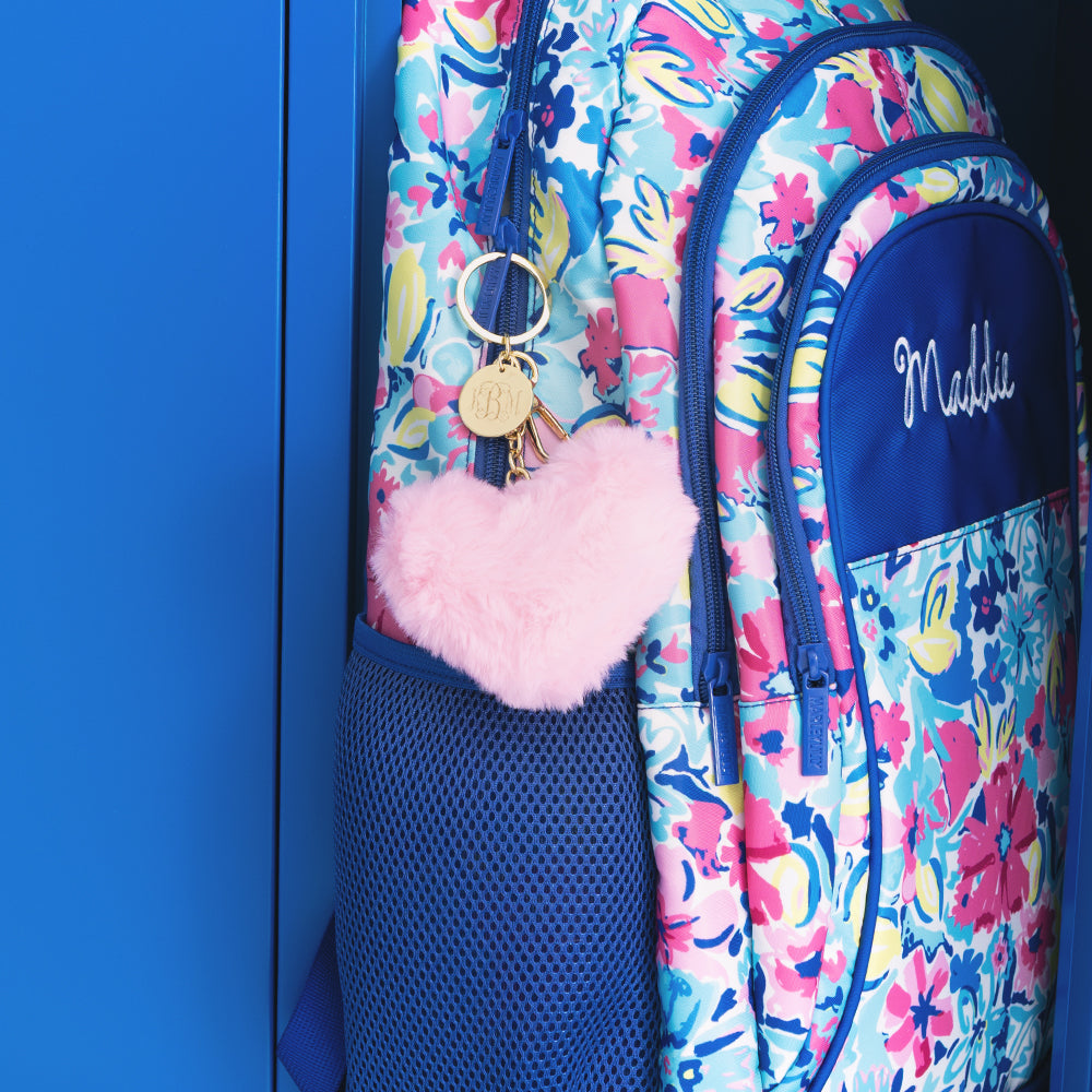 fuzzy pink monogrammed keychain on backpack in locker