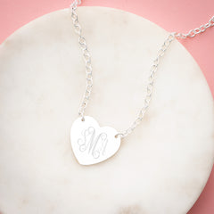 silver heart pendant necklace on marble dish