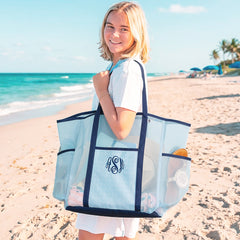 girl carrying monogrammed mesh tote in navy seersucker at beach