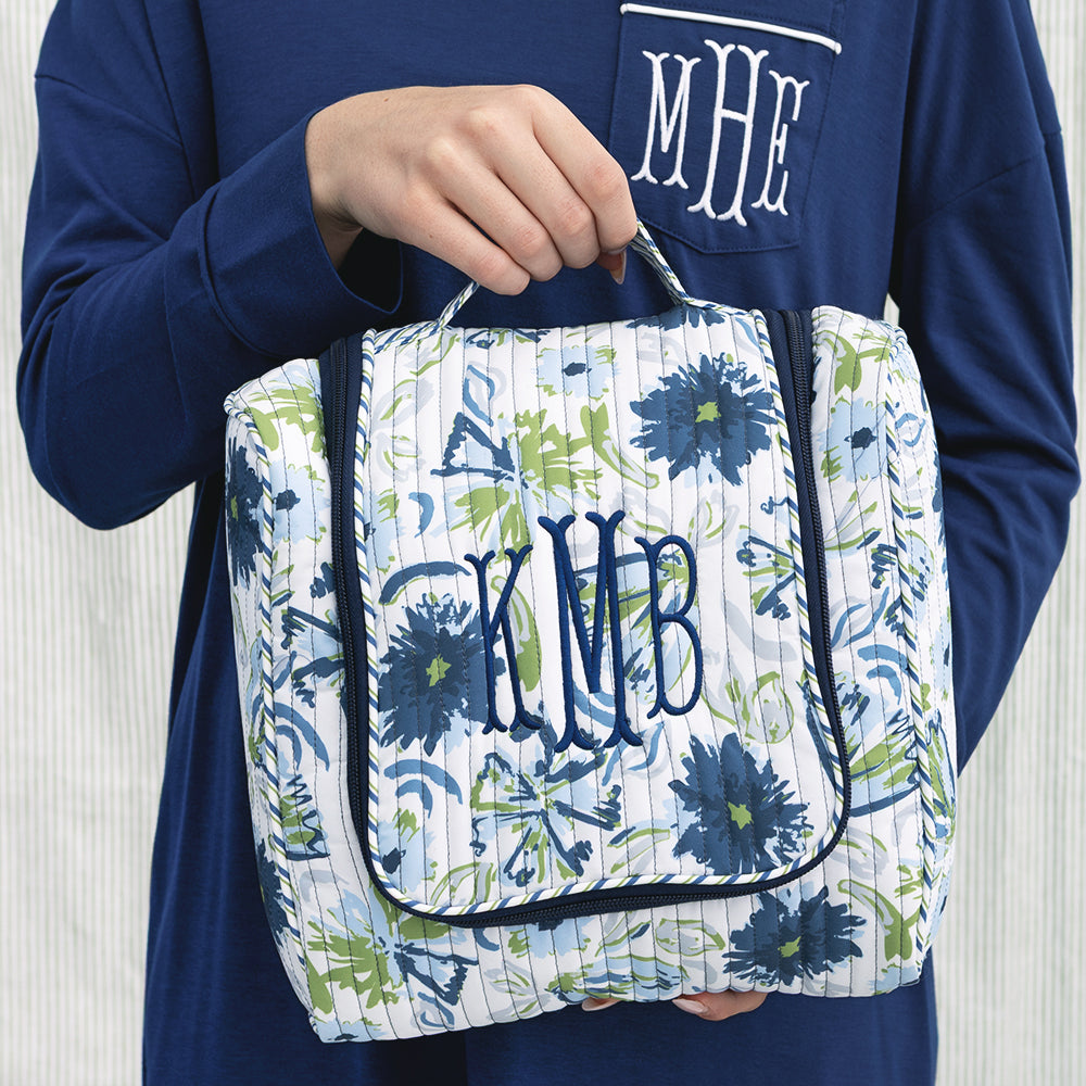 girl carrying indigo painted petals monogrammed quilted hanging toiletry bag 