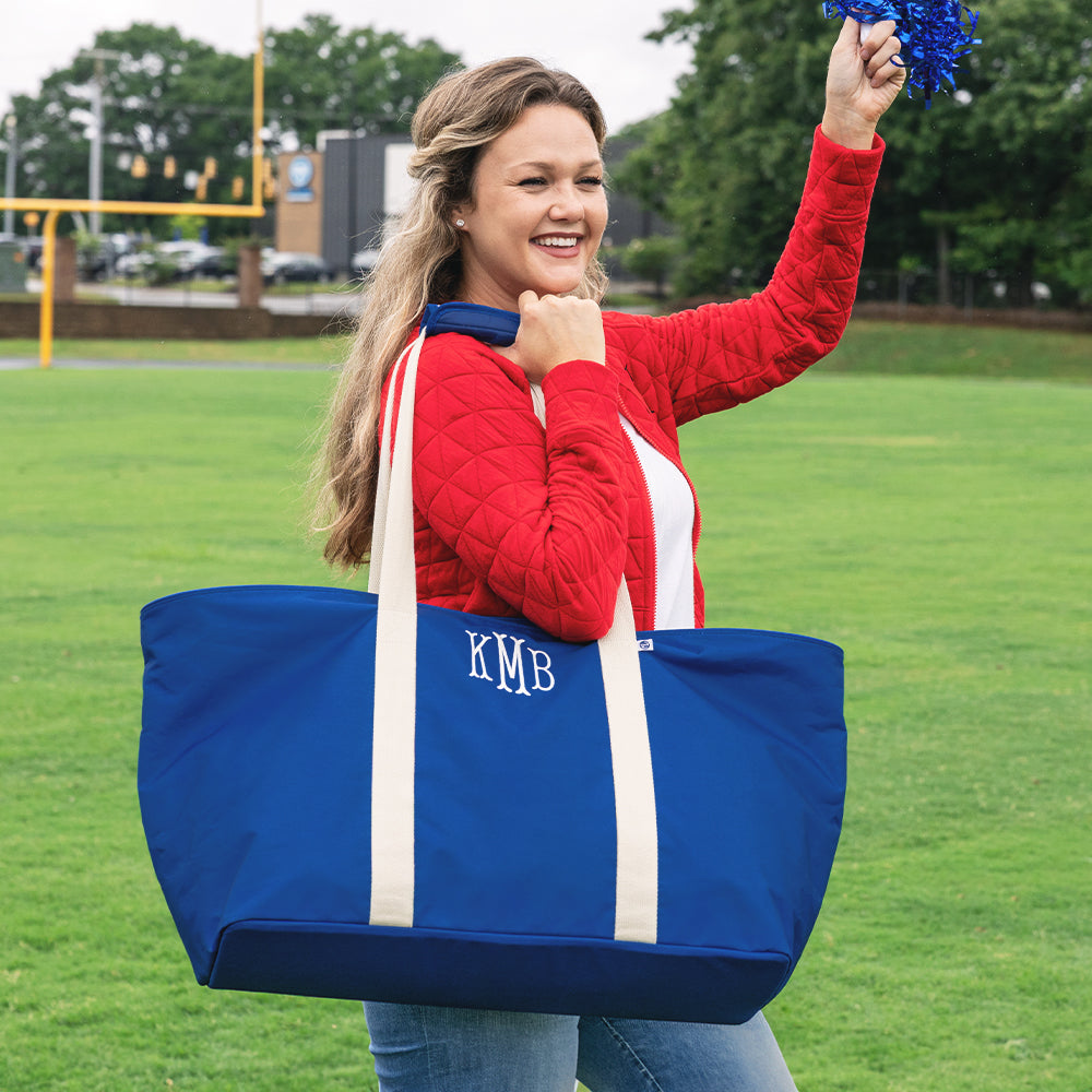 girl carrying monogrammed extra large tote bag in blue on football field 