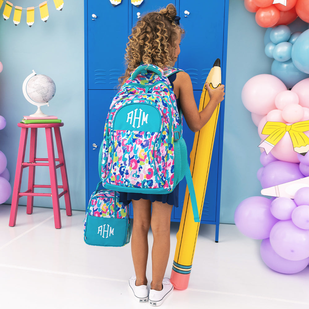girl carrying monogrammed lunch box and backpack in watercolor cheetah