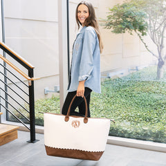 girl carrying monogrammed scallop vintage weekender in ivory 