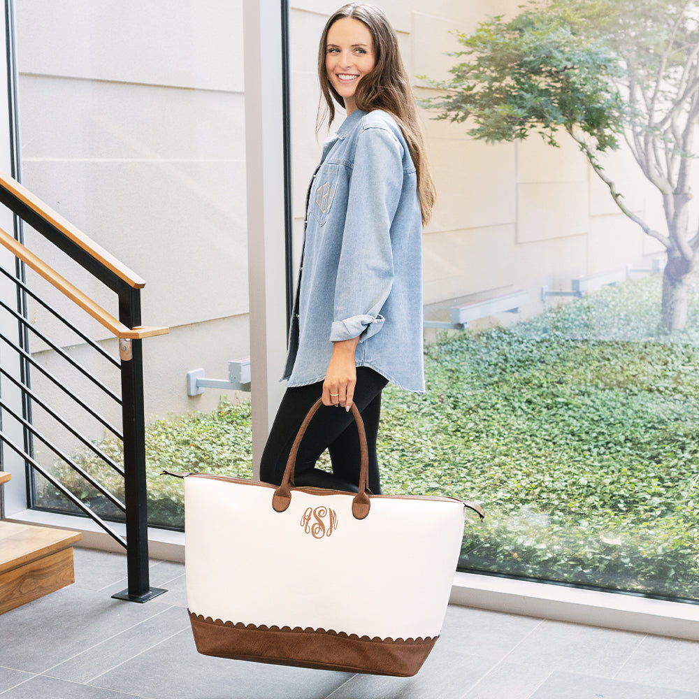 girl carrying monogrammed scallop vintage weekender in ivory 