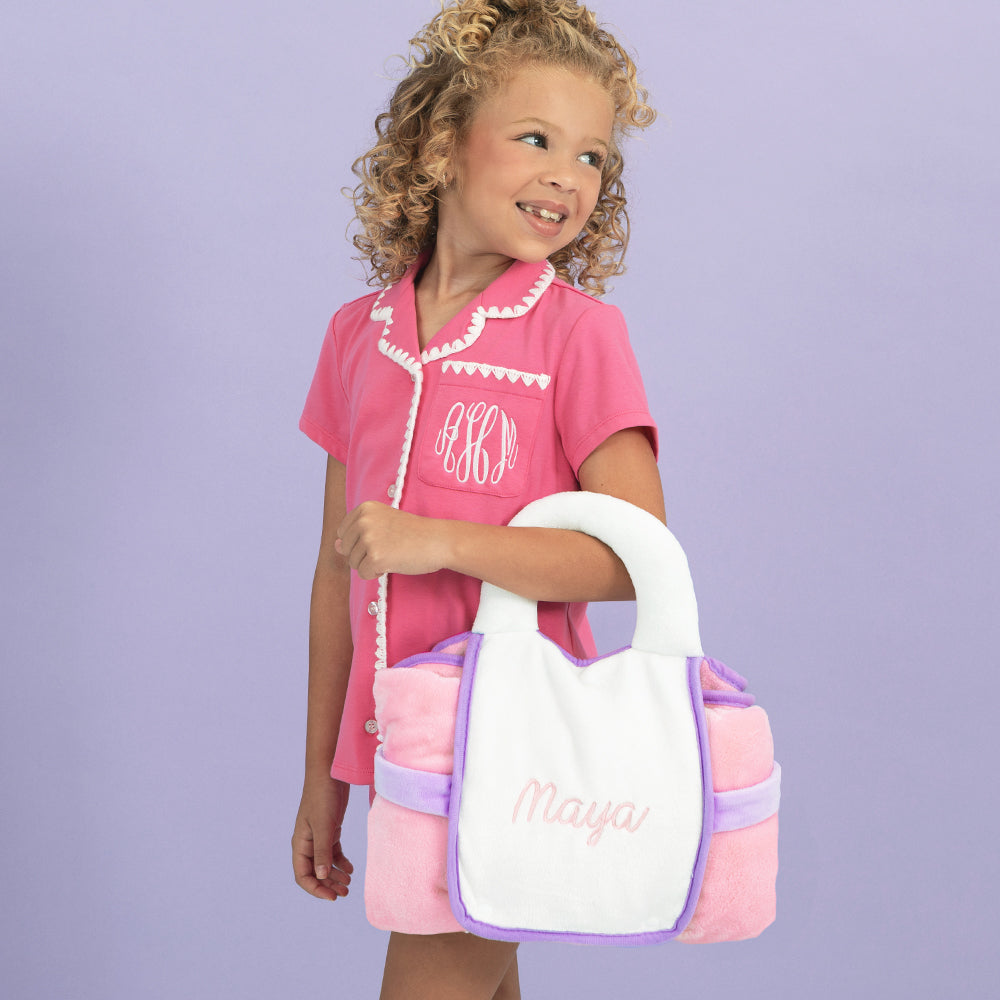 girl carrying packed monogrammed kids travel blanket 