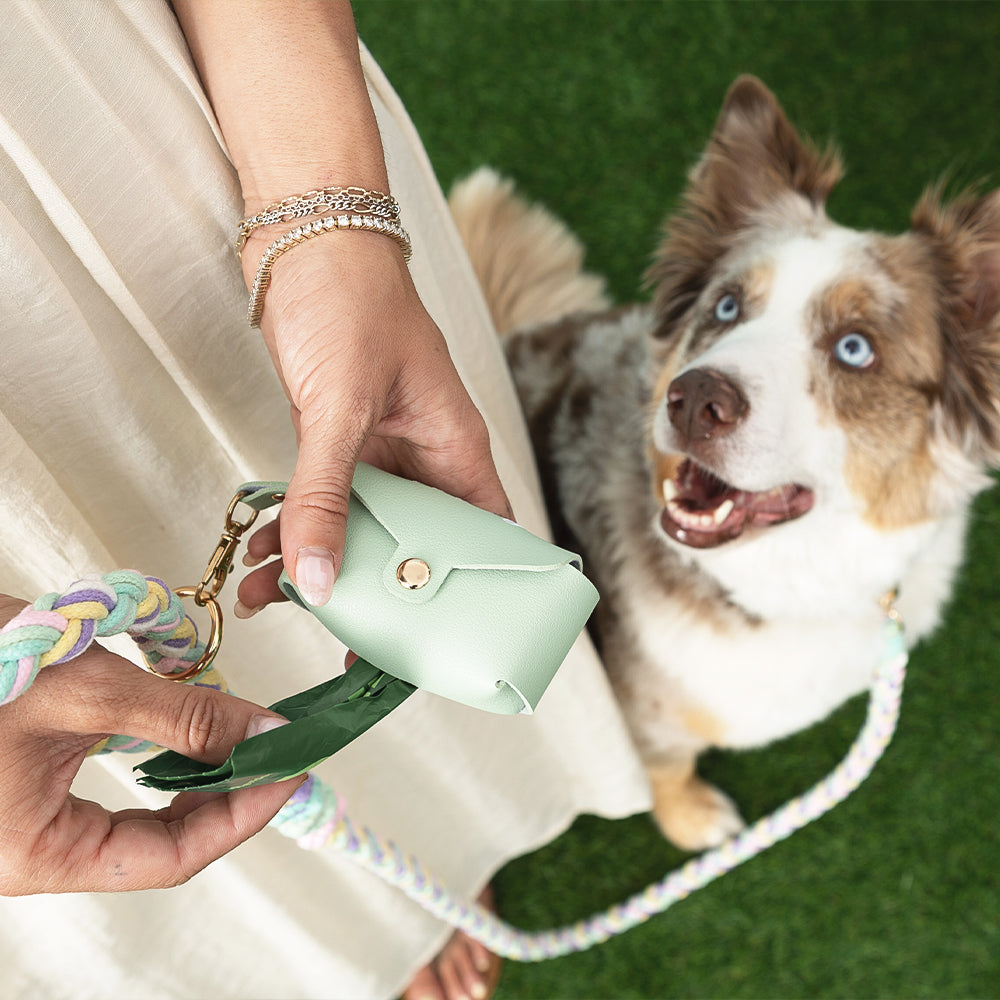 girl holding pet waste bag holder with dog