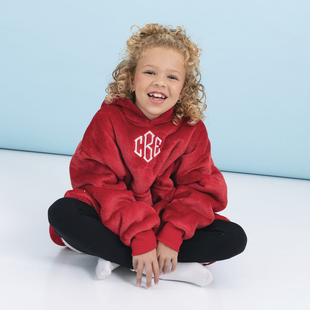 girl sitting wearing crimson monogrammed blanket hoodie