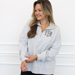 girl wearing heathered gray oversized quarter zip sweatshirt on white closeup