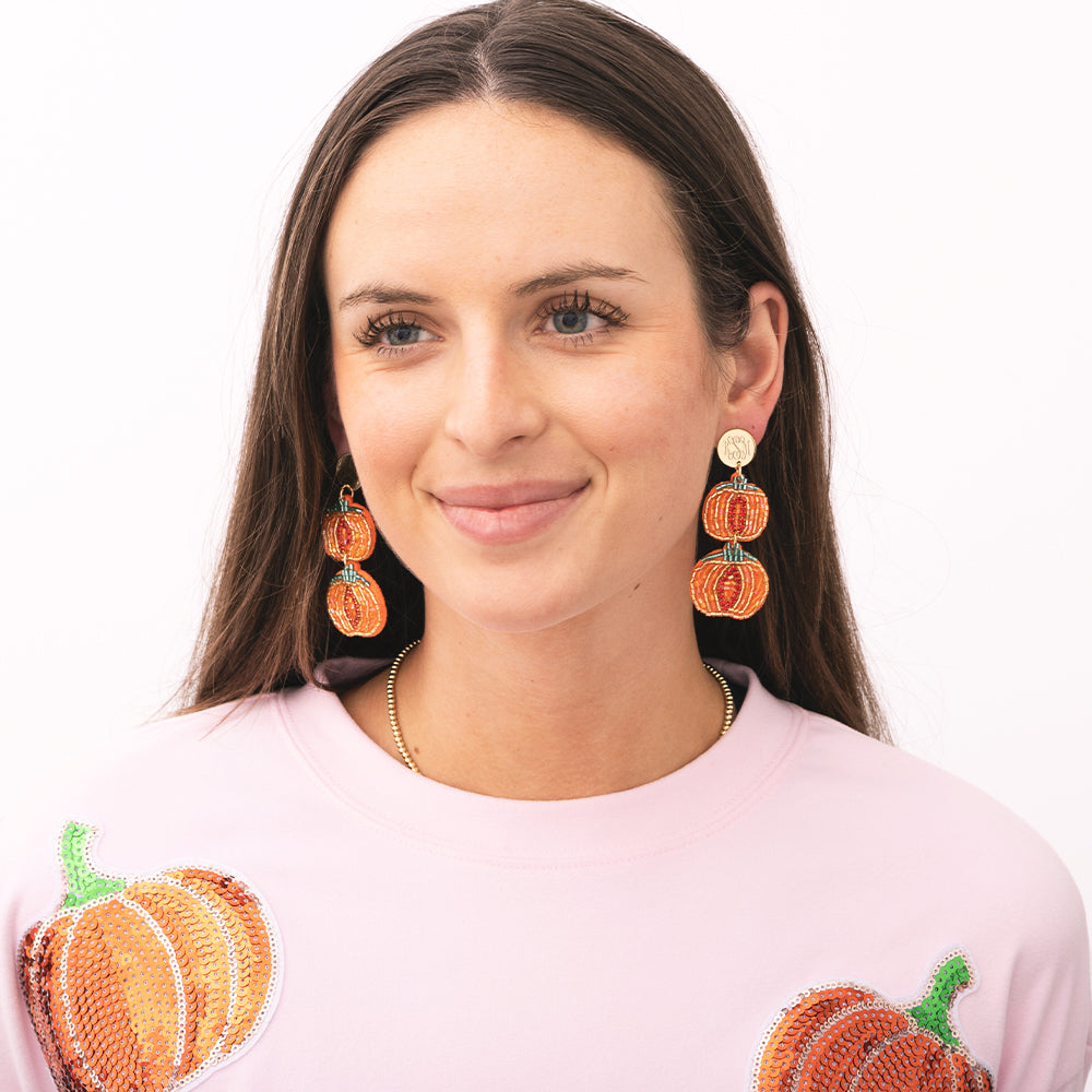 girl wearing monogrammed pumpkin earrings 