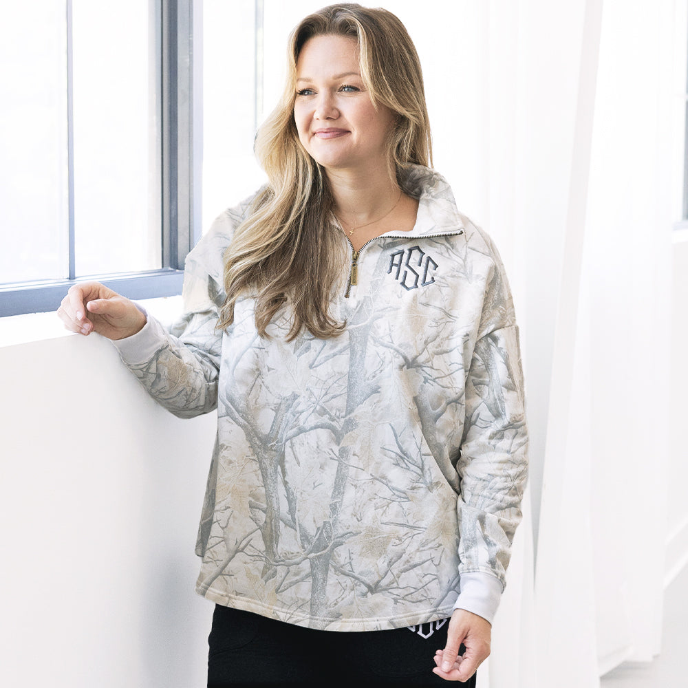 girl wearing monogrammed quarter zip sweatshirt in birch camo 