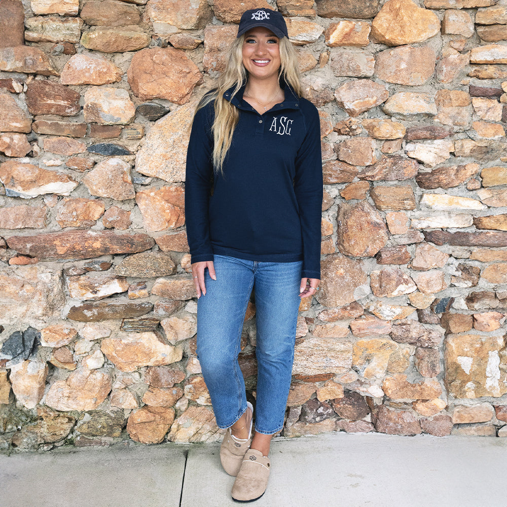 girl wearing navy monogrammed essential pullover with jeans and clogs 