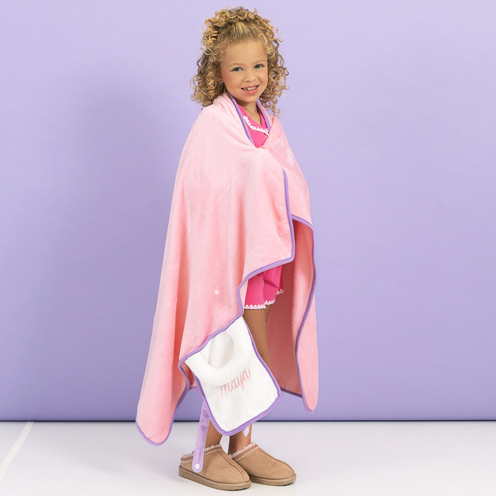 girl with monogrammed kids travel blanket wrapped around 