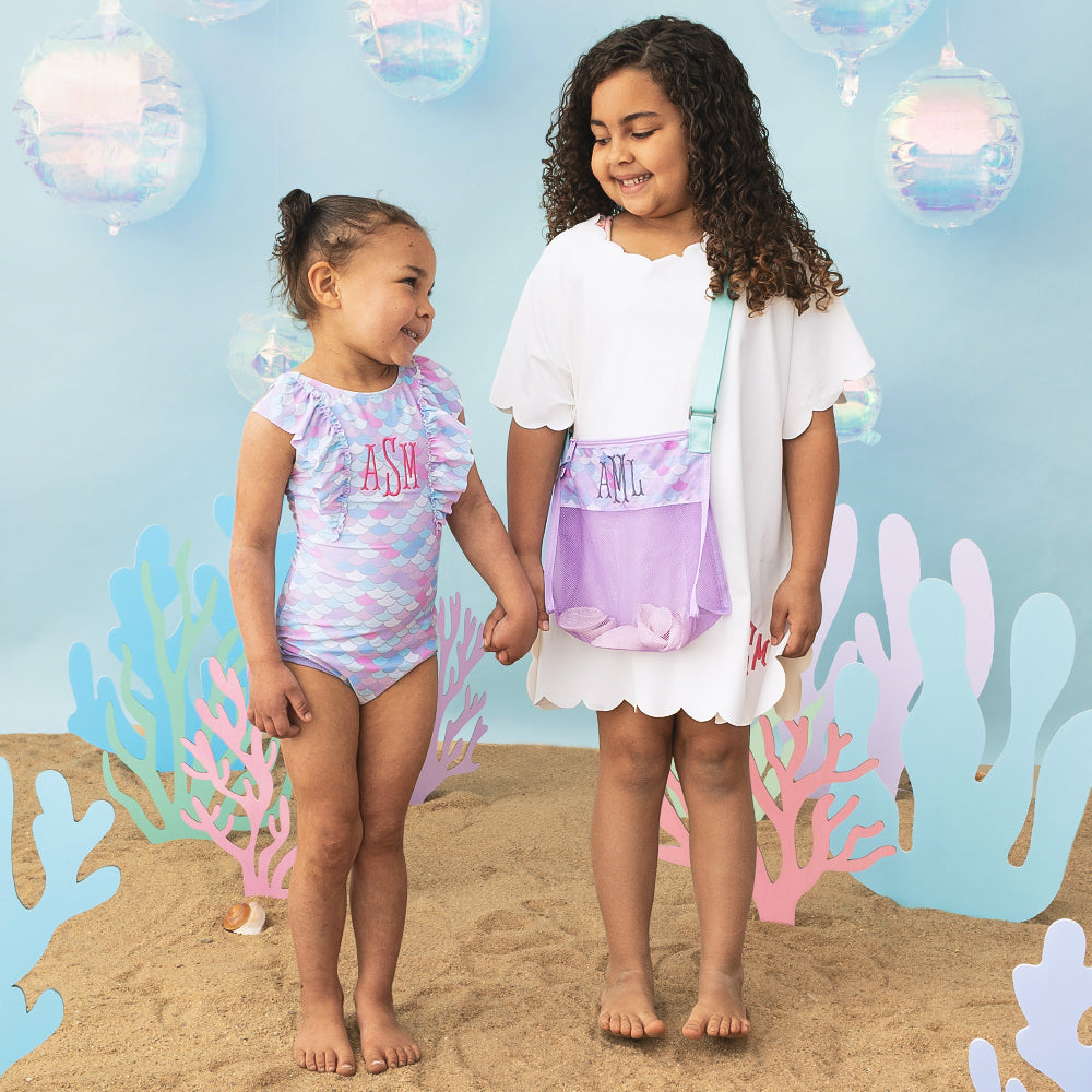 girls wearing monogrammed bathing suit and scallop cover up in white