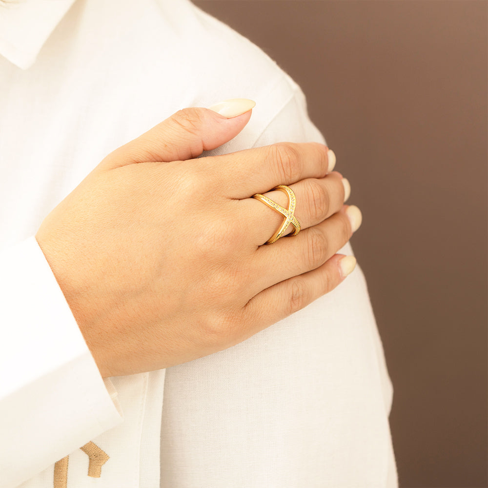 gold adjustable criss cross ring on hand with white shirt
