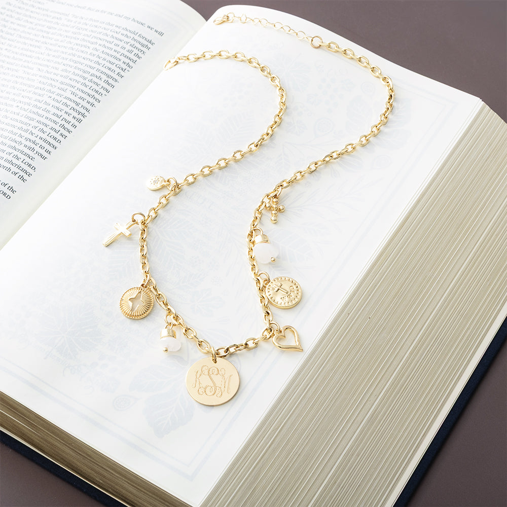 gold signature charm necklace on open bible