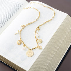 gold signature charm necklace on open bible