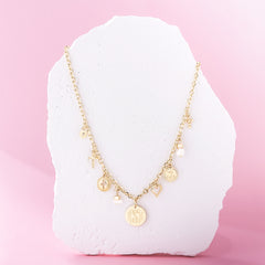 gold signature charm necklace on stone