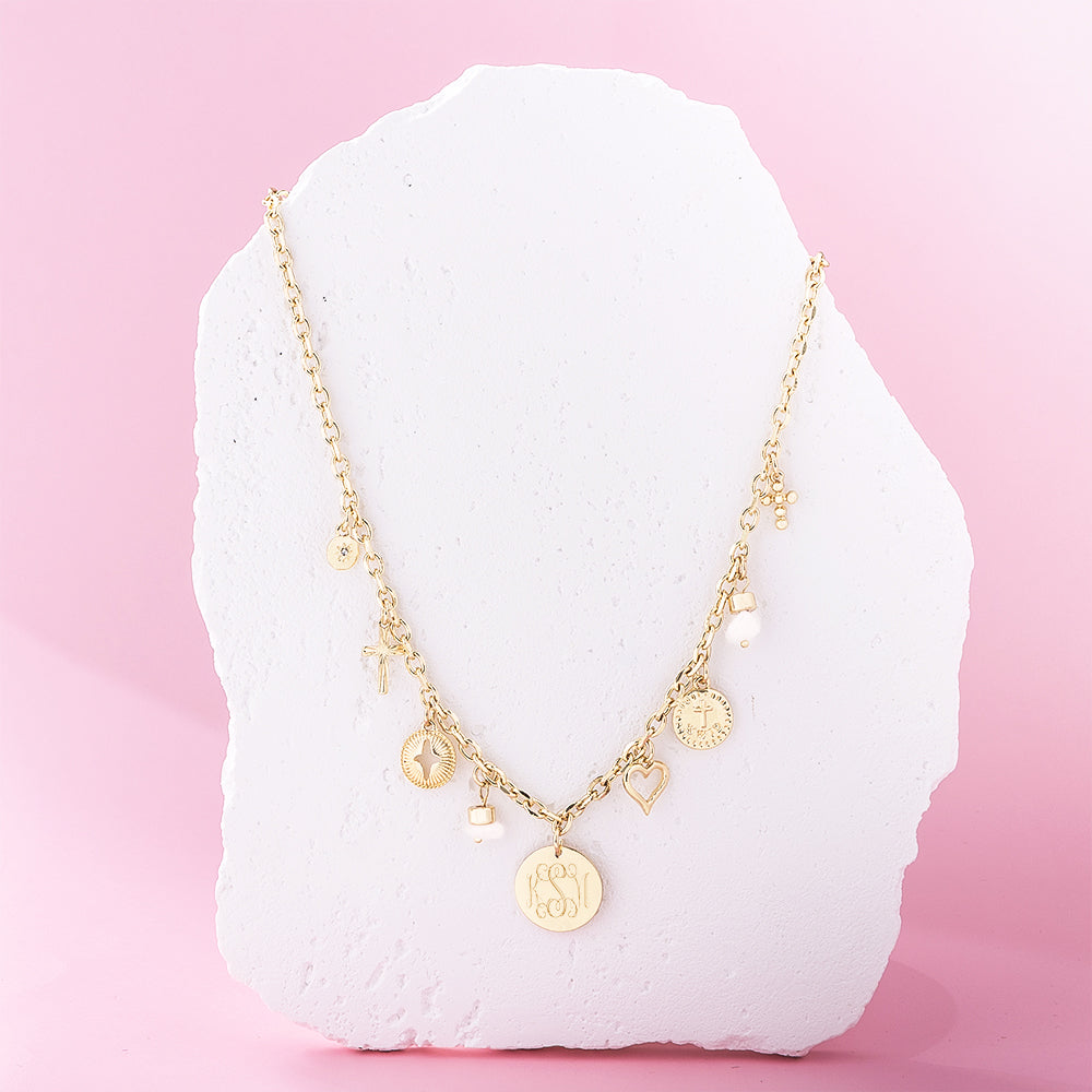 gold signature charm necklace on stone