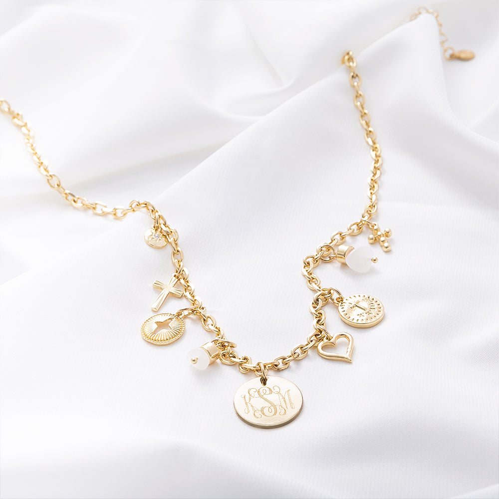 gold signature charm necklace on white satin