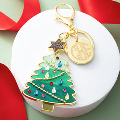 green Christmas bag charm keychain on tray with ribbon