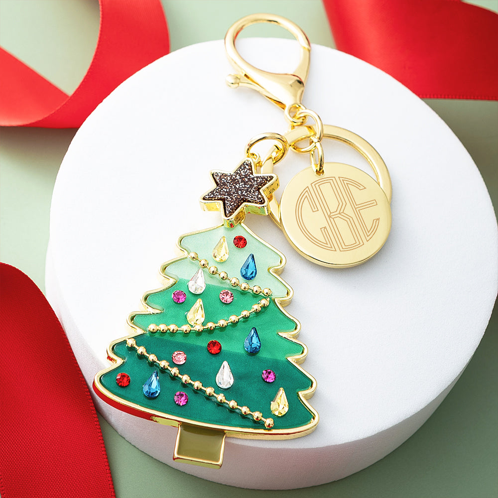 green Christmas bag charm keychain on tray with ribbon