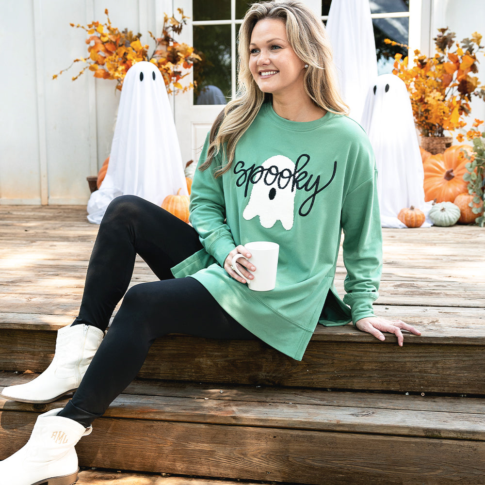 green spooky sweatshirt on emily sitting on porch