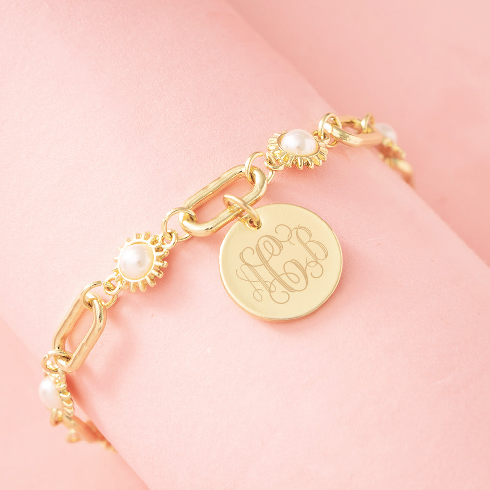 gold personalized pearl starburst bracelet on pink background