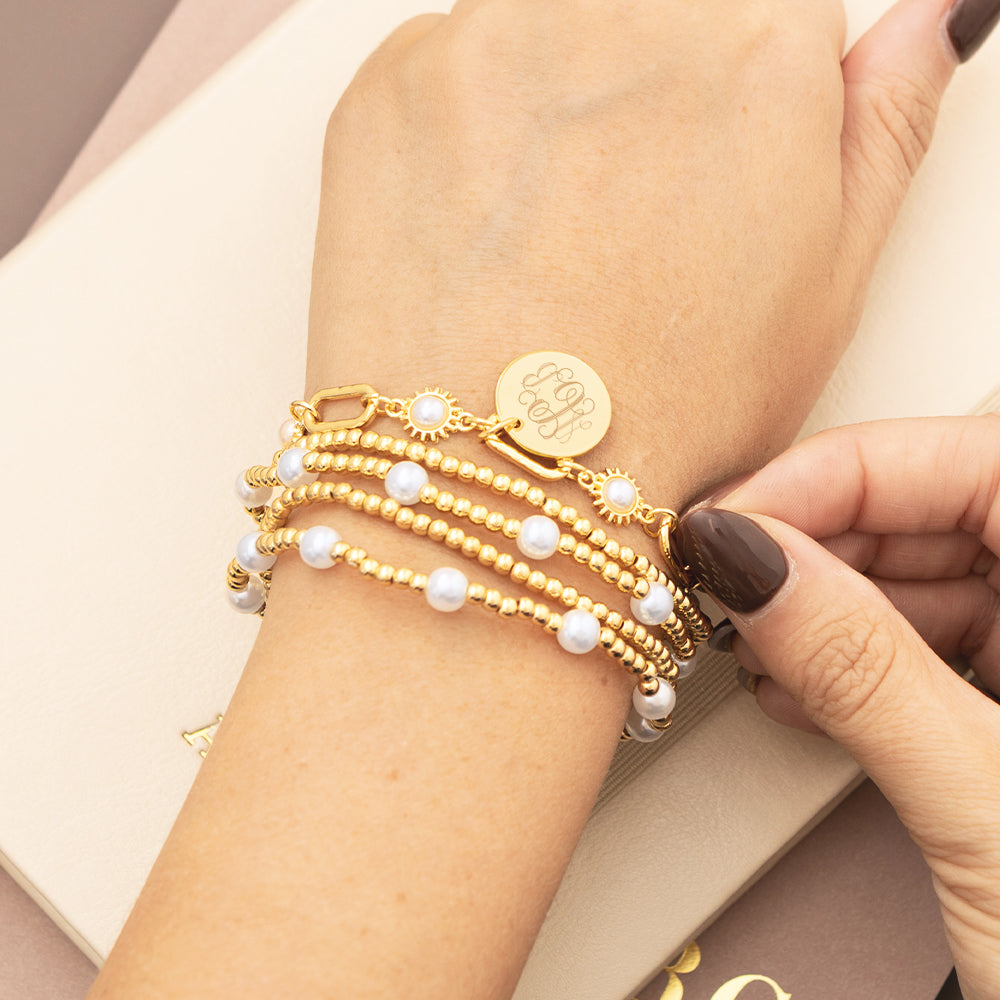 pearl starburst gold monogrammed bracelet on wrist