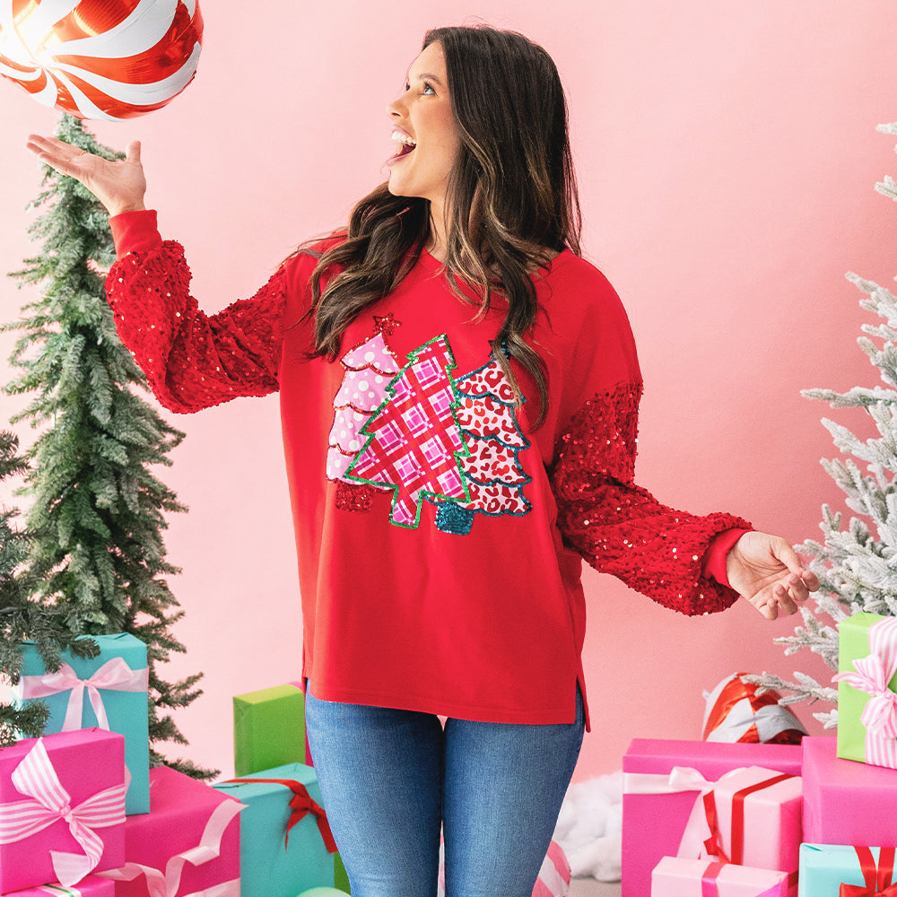 girl wearing red christmas tree sweatshirt with balloon