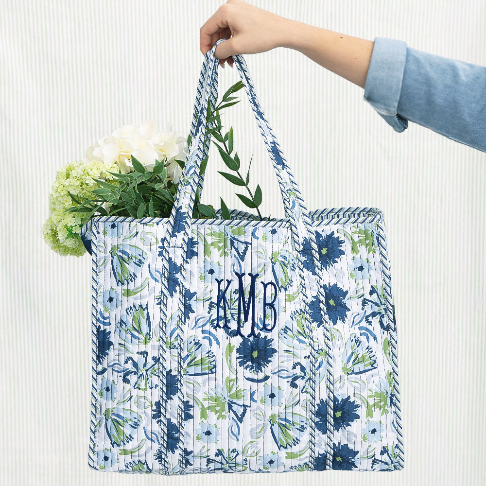 indigo painted petals monogrammed quilted tote bag on green seersucker background 