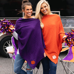 girls at tailgate in clemson ponchos with orange and purple pom poms