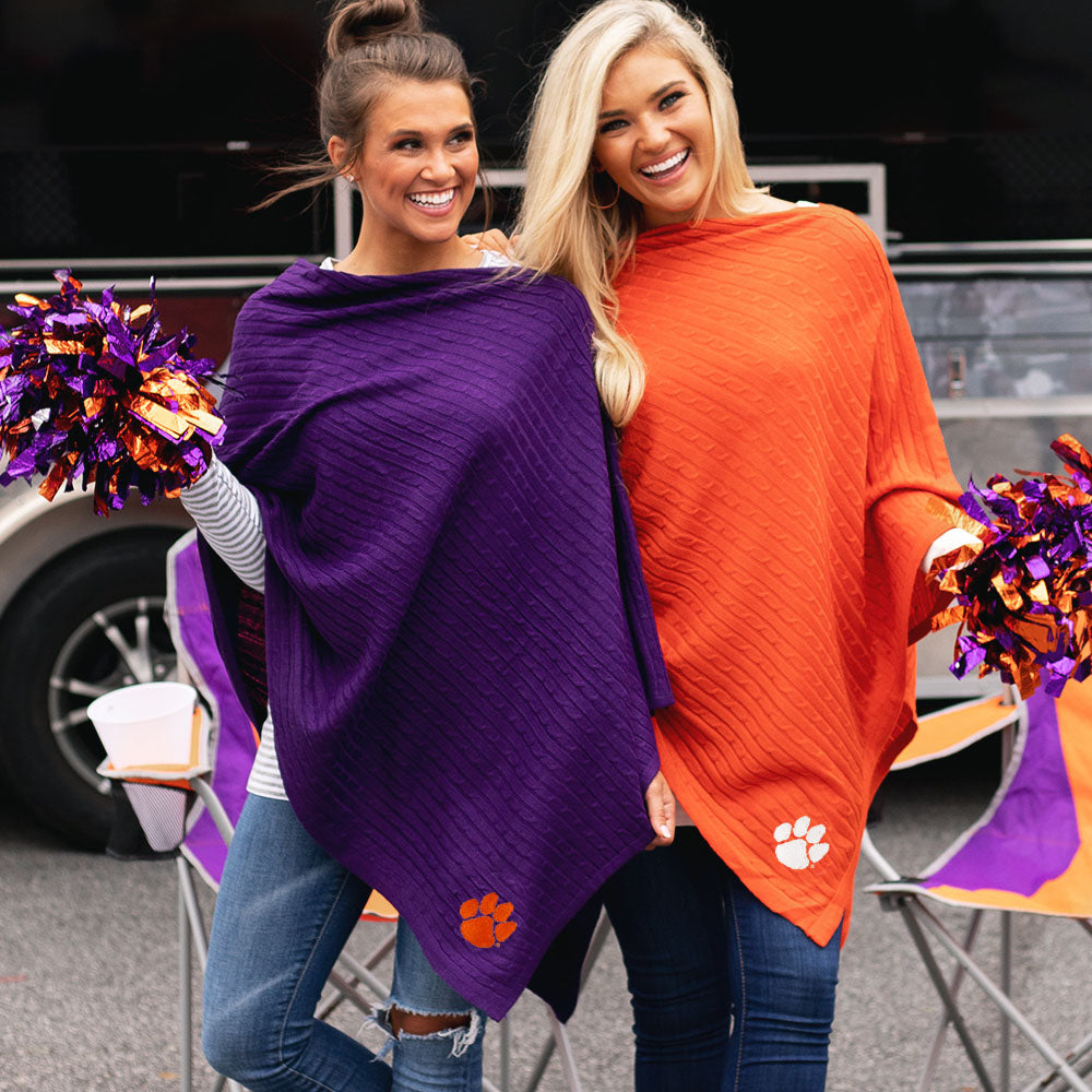 girls at tailgate in clemson ponchos with orange and purple pom poms