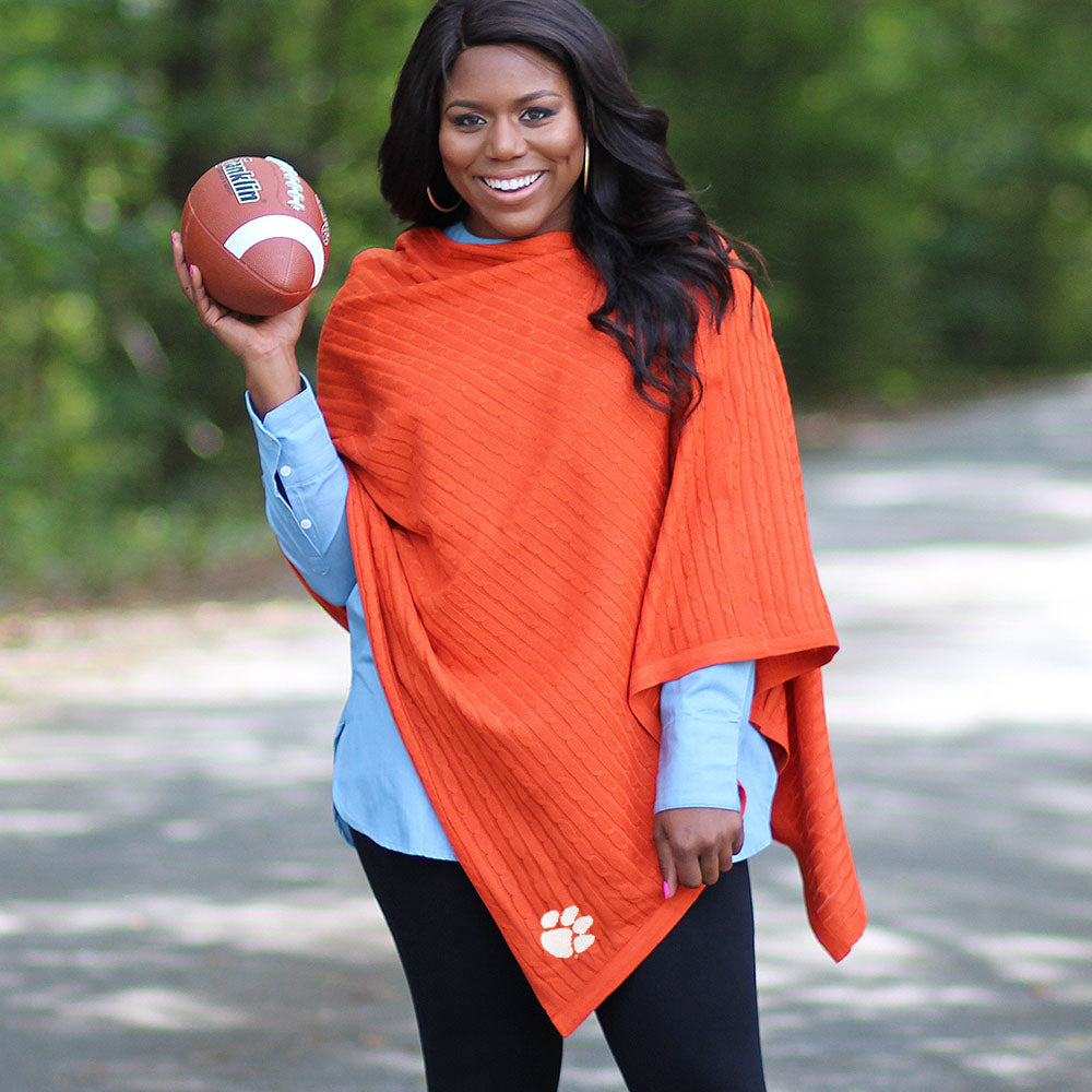 girl holding football wearing clemson orange poncho