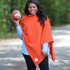 girl holding football wearing clemson orange poncho